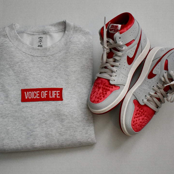 Signature ash color sweatshirt folded with red and grey Jordan Ones